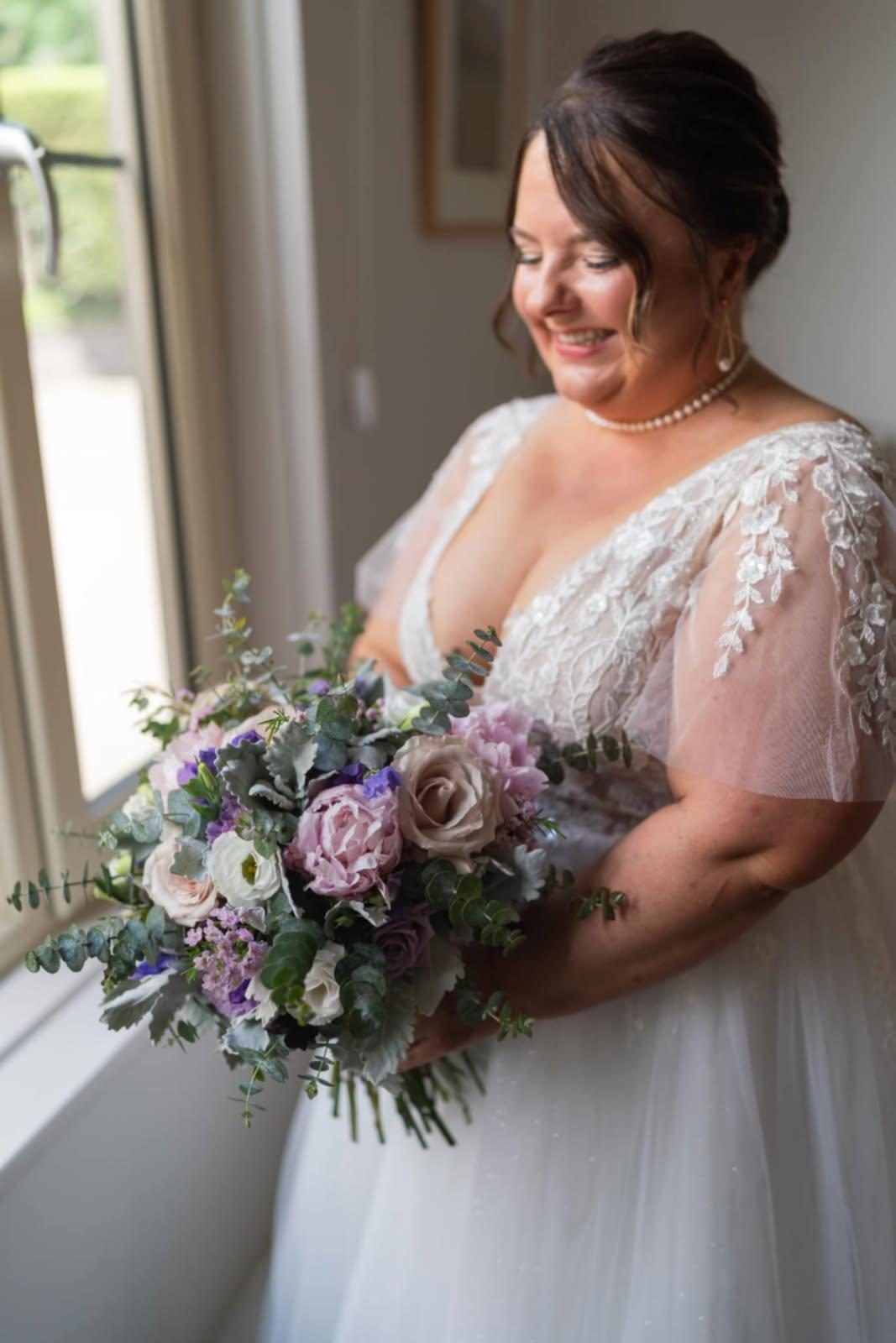 Bride in lace gown by a sunlit window