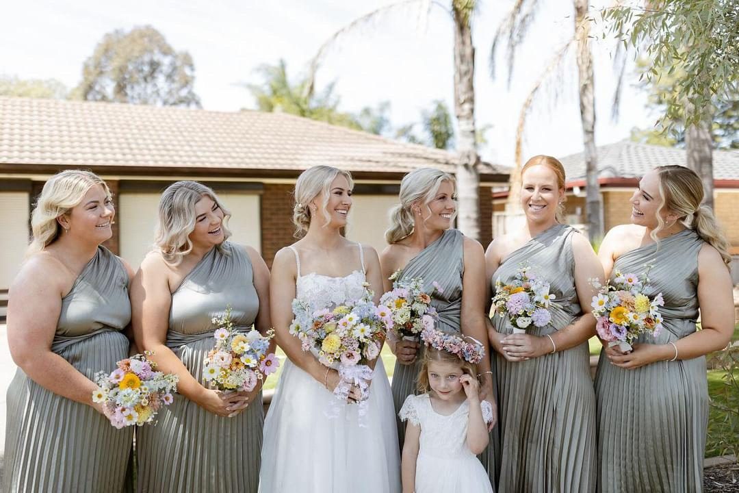 Bride and bridesmaids in champagne gowns outdoors