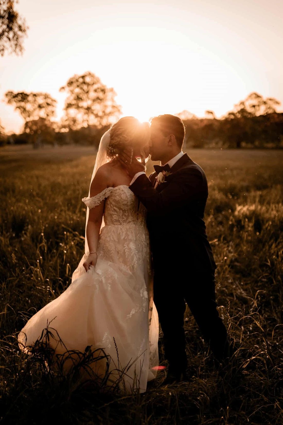 Bride and groom, backlit sunset embrace