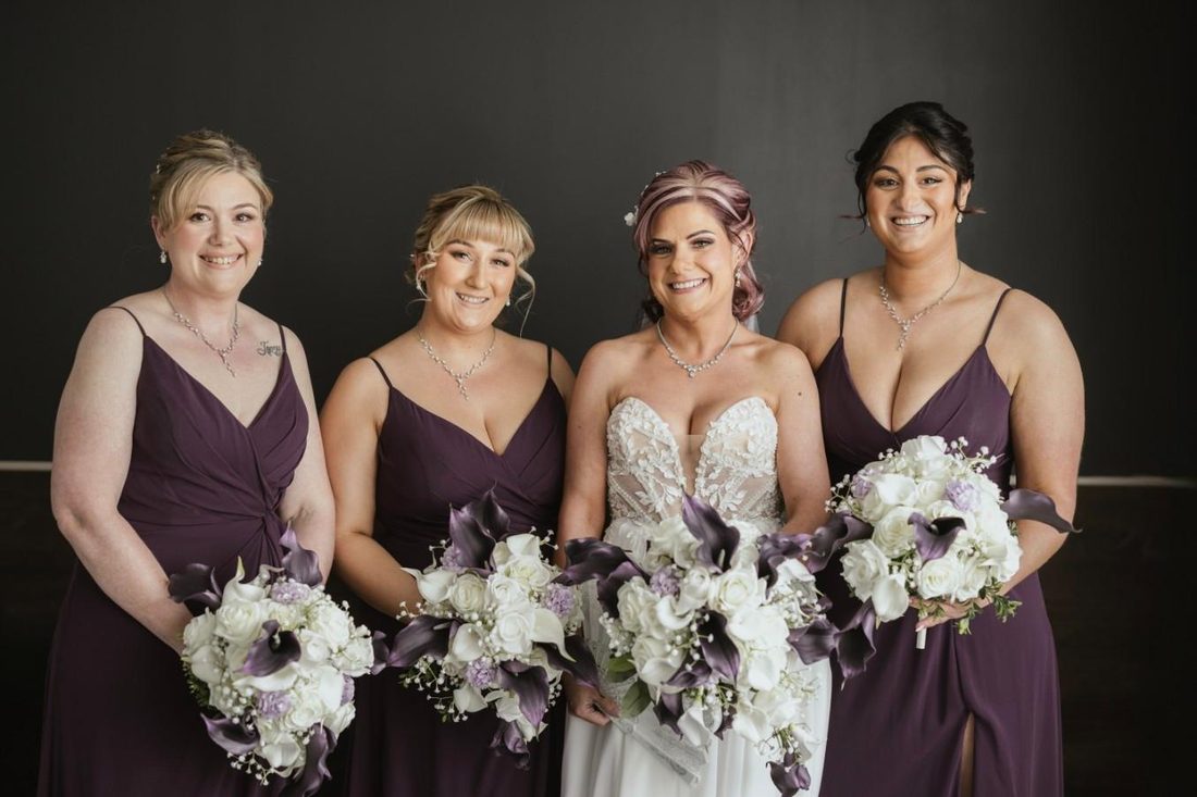 Bridesmaids in deep plum gowns