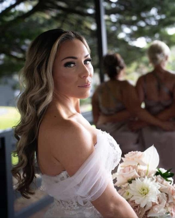 Bride looking back over her shoulder, bridesmaids softly blurred behind